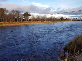 A river in Scotland at high flow. The picture also shows the cableway across the river where spot gaugings can be taken in times of high flow.